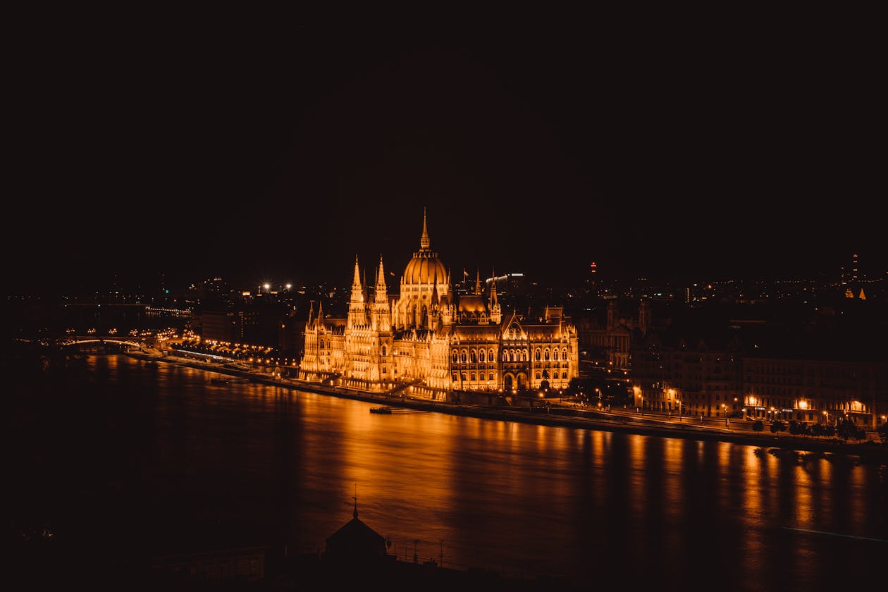 Aerial view of the illuminated Hungarian Parliament Building along the Danube River at night