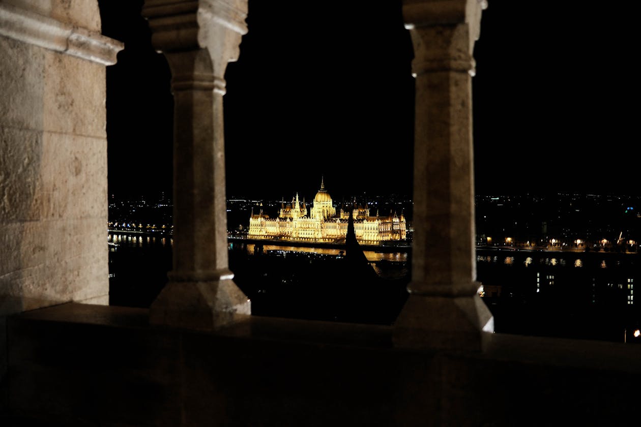 Parliament Building seen through a stone archway illuminated at night