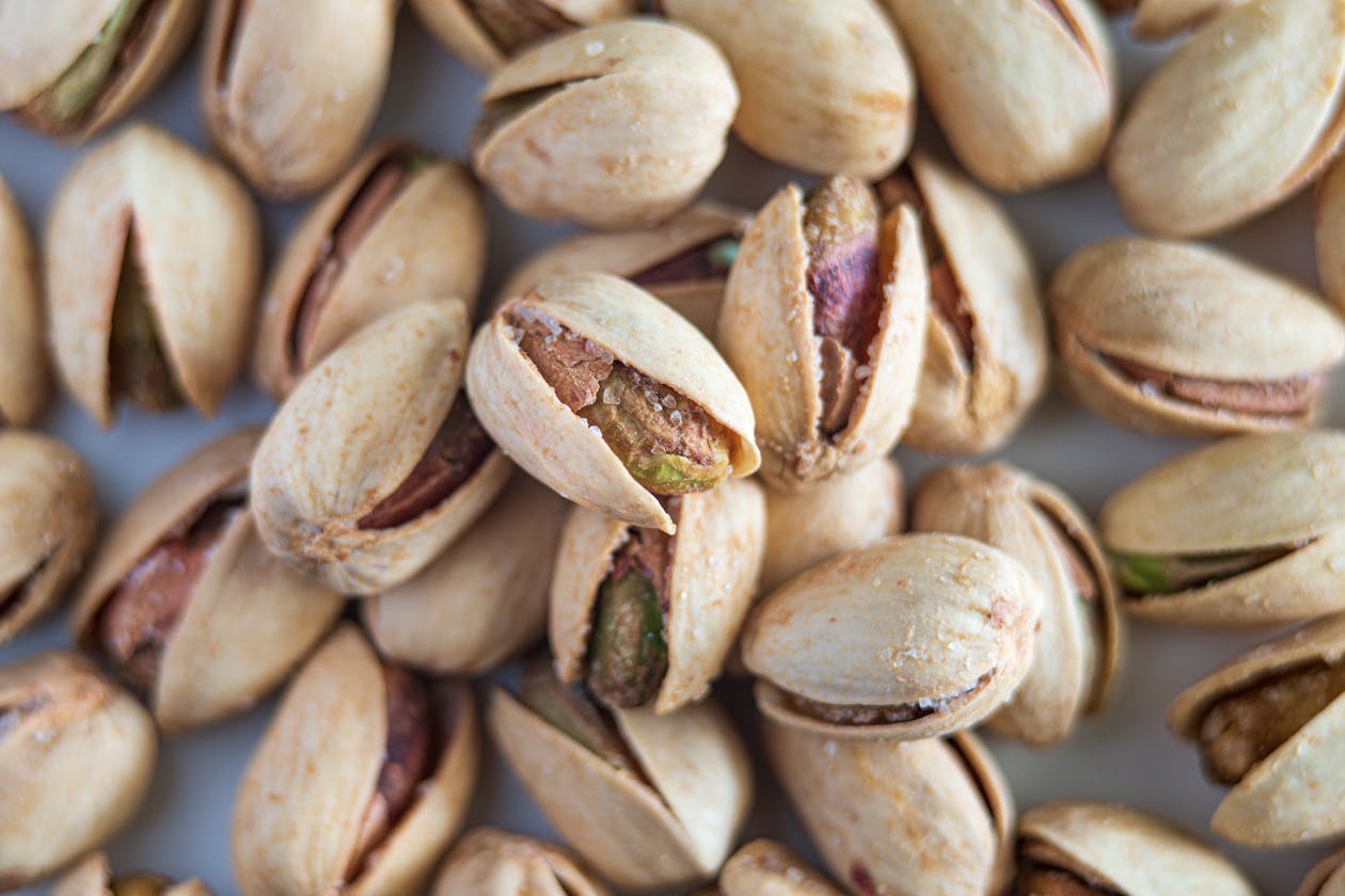 Close-up of salted pistachios in their shells showing green and brown colors