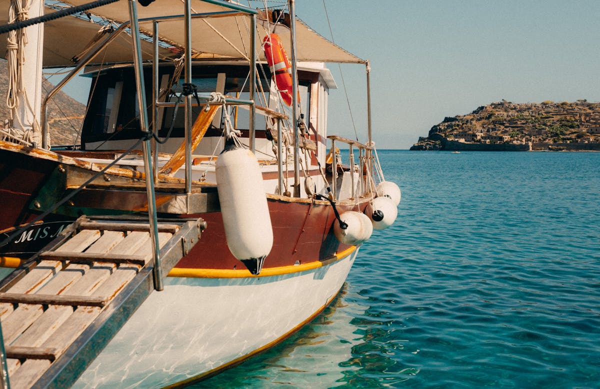 A traditional wooden boat on crystal-clear turquoise Mediterranean waters