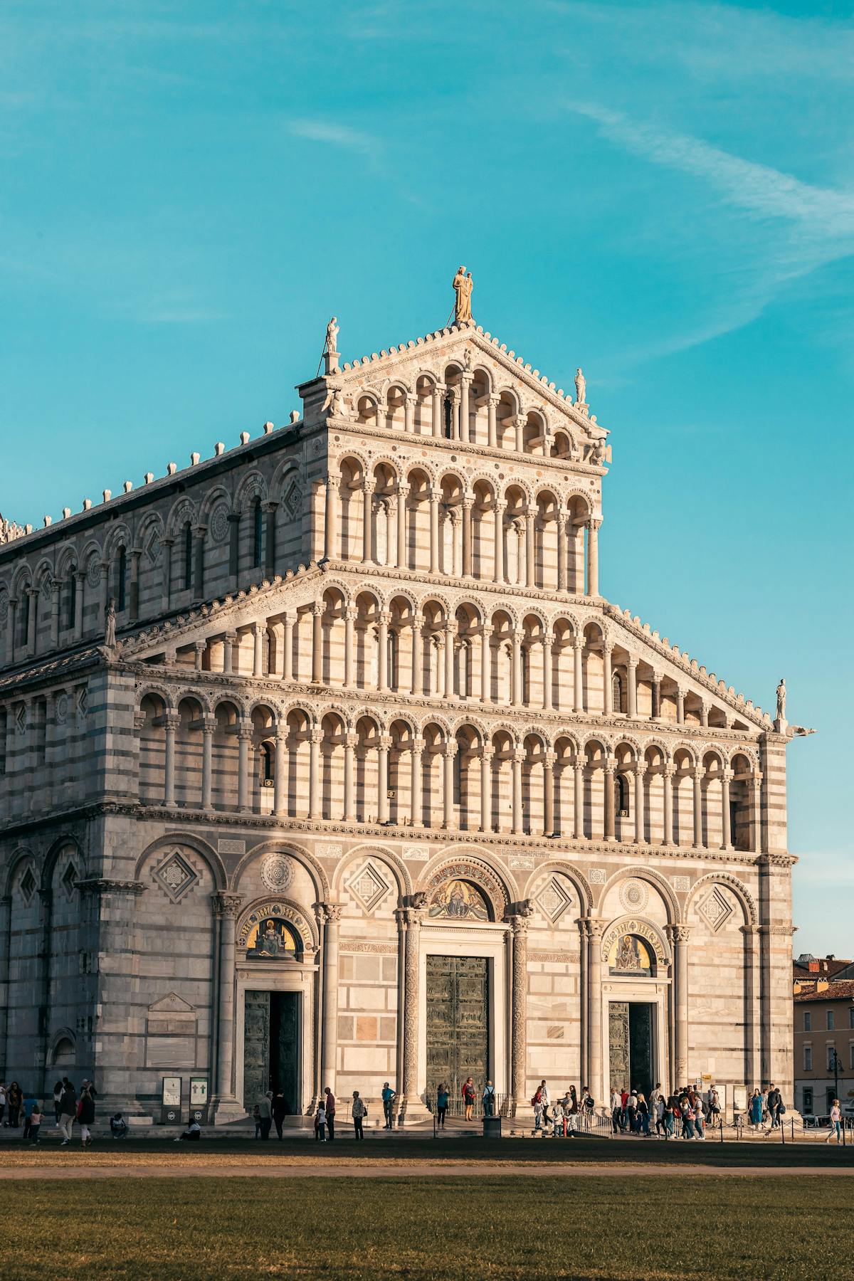 Detailed view of the Pisa Cathedral Romanesque facade with travelers in the foreground