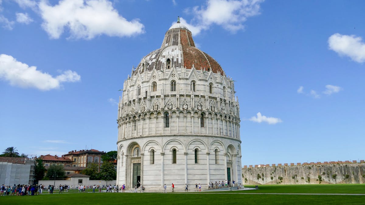 The green lawn of the Piazza dei Miracoli with the Leaning Tower in the background