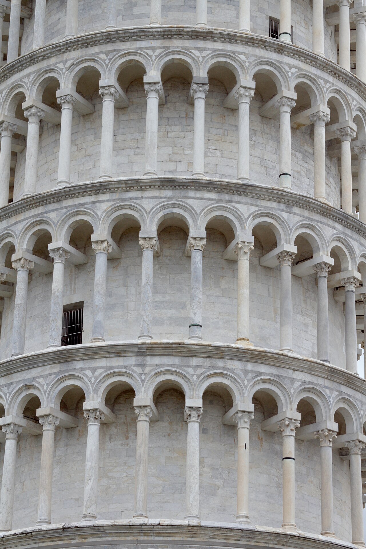 The ornate loggia columns wrapping around the exterior of the Leaning Tower of Pisa