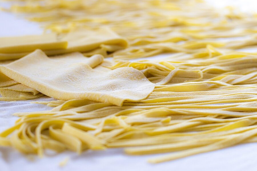 Fresh handmade tagliatelle pasta nests on a wooden surface