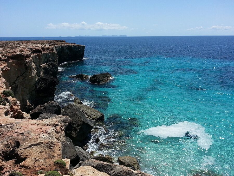 Small cove in Mallorca with clear blue water surrounded by rocks