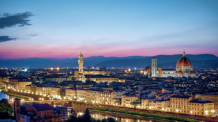 Florence skyline at sunset with the Duomo dome and bell tower silhouetted against golden sky