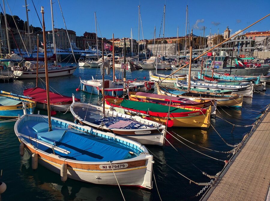 Wide view of the Old Port in Cannes with boats and the Suquet hill in the background
