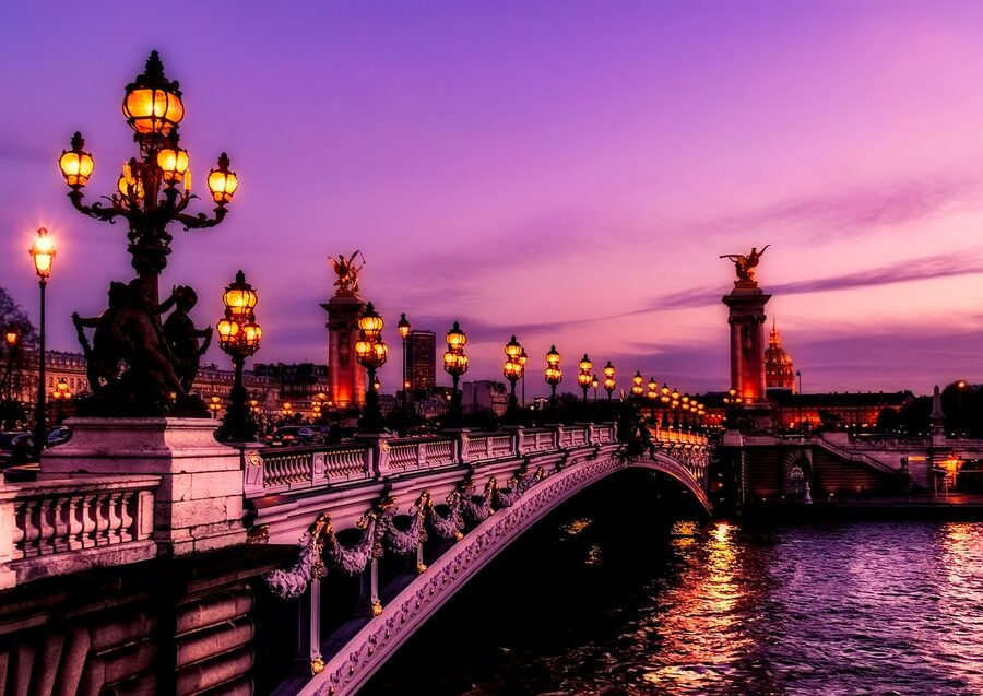 Paris bridges and monuments at sunset with golden light reflecting on the Seine
