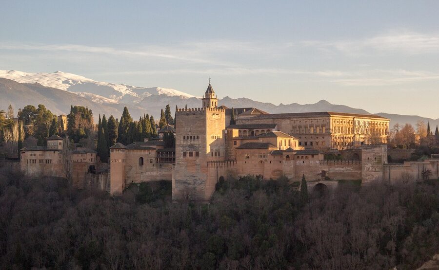 The Alhambra palace at sunset with warm orange light reflecting off the stone walls