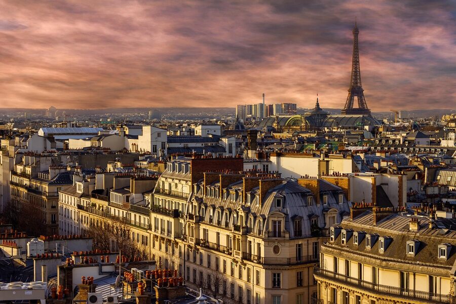 Panoramic night view of Paris rooftops with Eiffel Tower in the distance