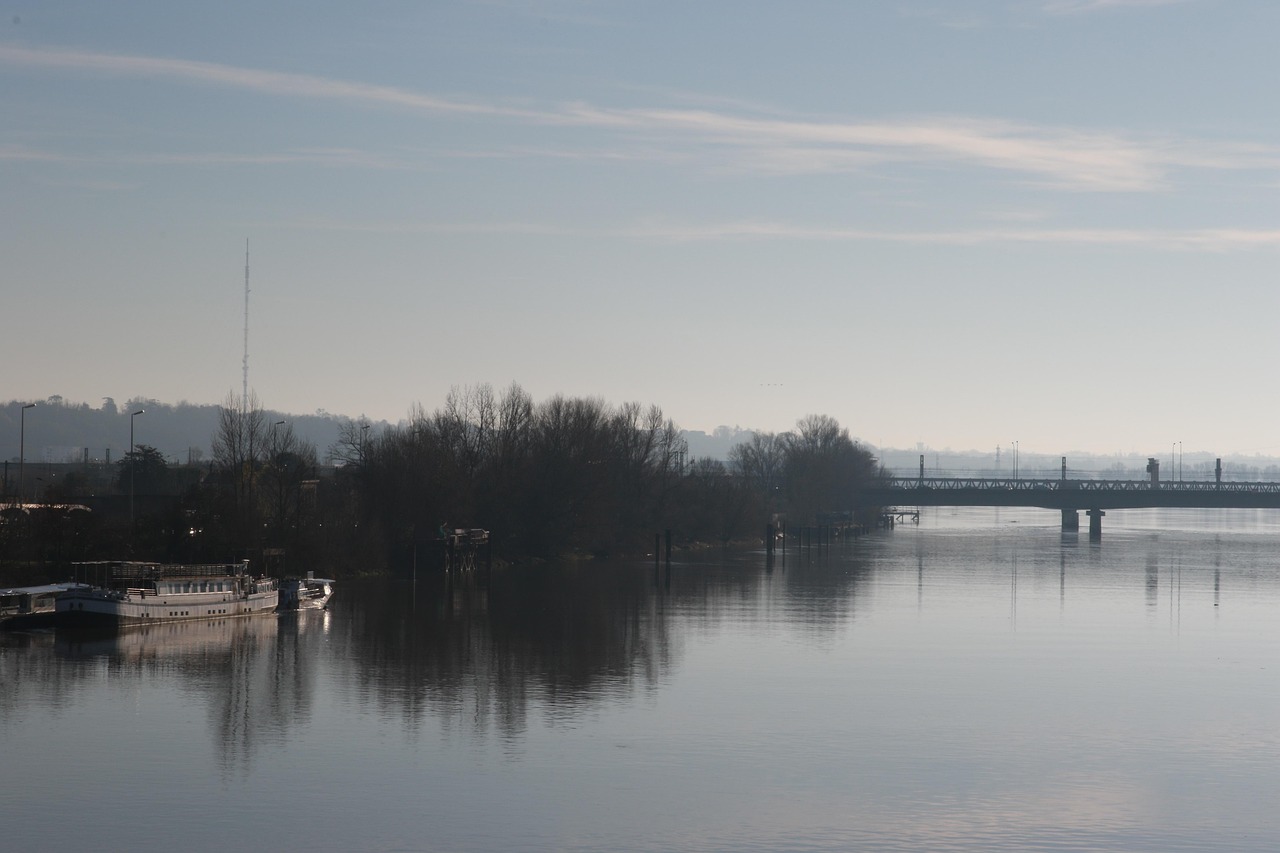 A boat on the Garonne River in Bordeaux with a bridge and city buildings in the background
