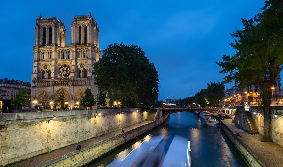 Notre Dame and Seine River at night with illuminated buildings in Paris