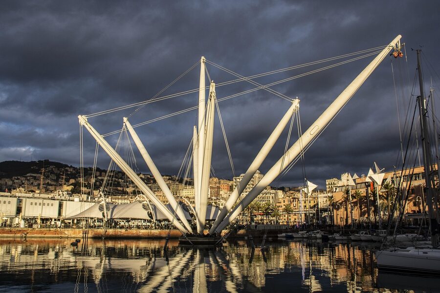 The Genoa old port area with the aquarium building at sunset with golden reflections on the water