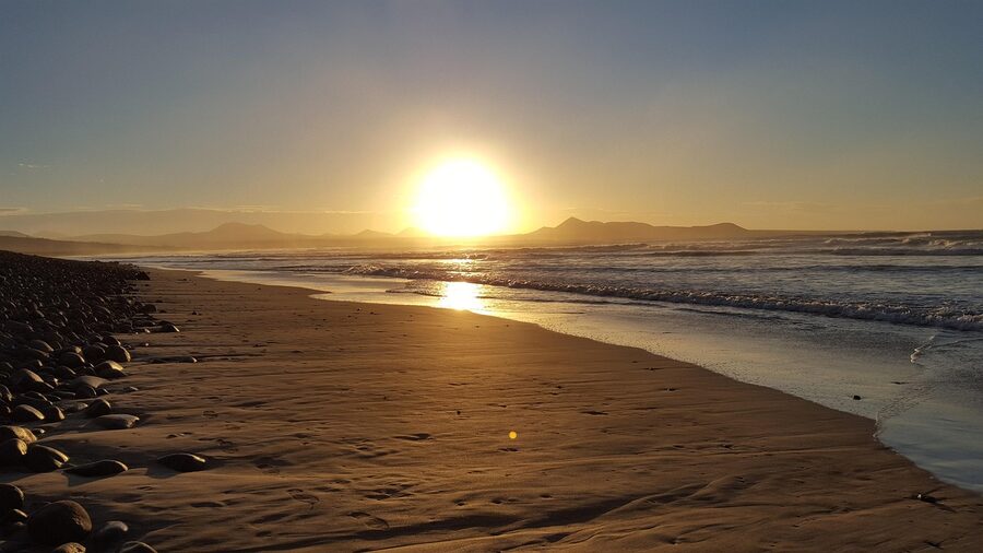 Sunset over Famara beach with silhouetted cliffs in Lanzarote