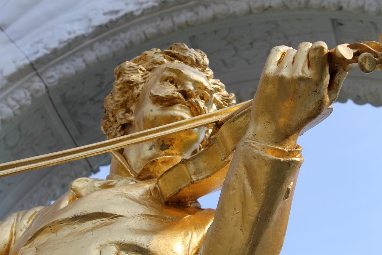 Golden statue of Johann Strauss playing violin in the Stadtpark in Vienna