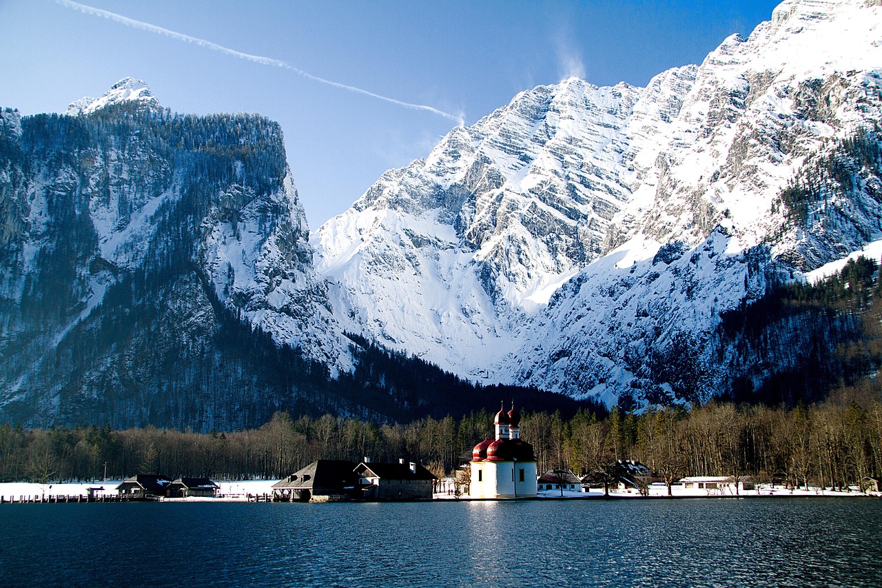 Konigssee lake with the red-domed St Bartholomew church surrounded by snow-covered Alps
