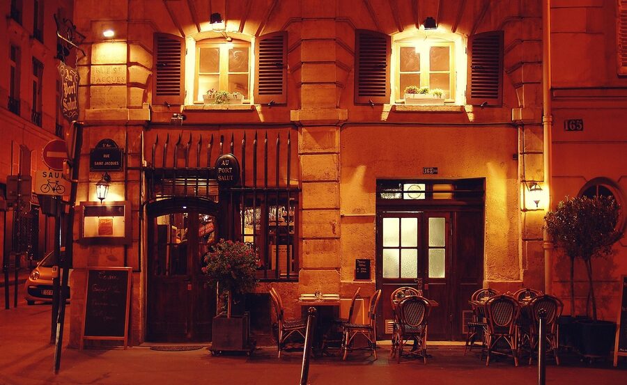 Illuminated Parisian restaurant and bar facade at night