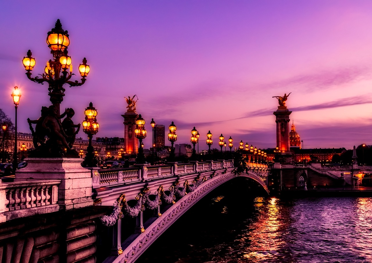 Panoramic view of Paris at sunset with bridges over the Seine River and city lights