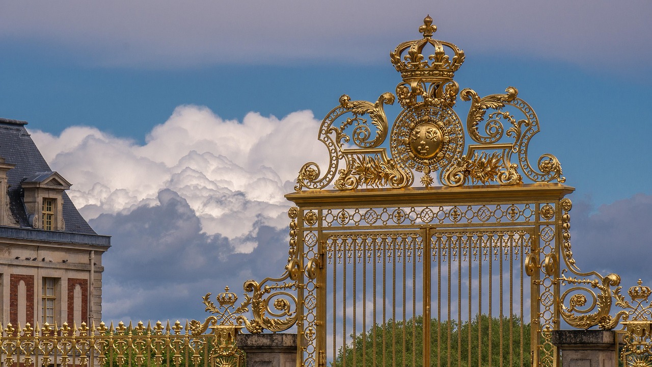 Ornate golden gate entrance to the Palace of Versailles with intricate metalwork