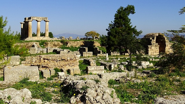 Panoramic view of Ancient Corinth archaeological site with ruins and mountains behind
