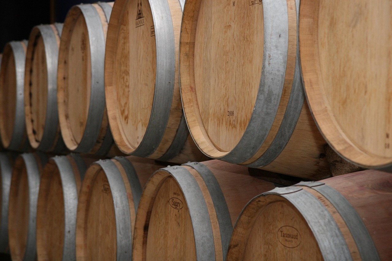 Rows of wine barrels stacked in a traditional Bordeaux winery cellar