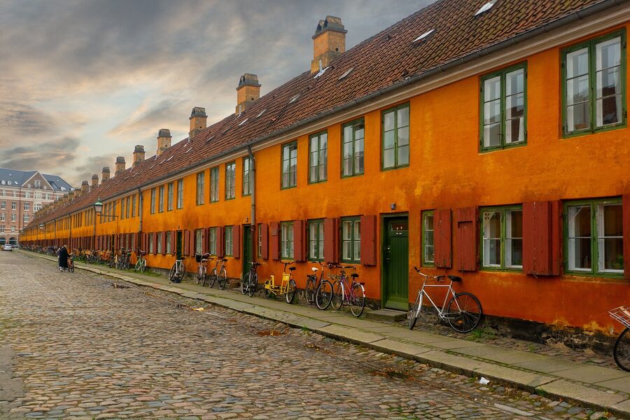 Bicycles parked outside old yellow row houses in Nyboder Copenhagen