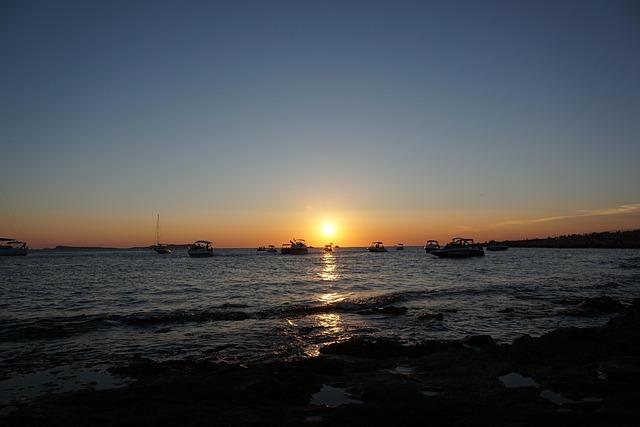 Sunset over boats and sea in Sant Antoni de Portmany Ibiza Spain
