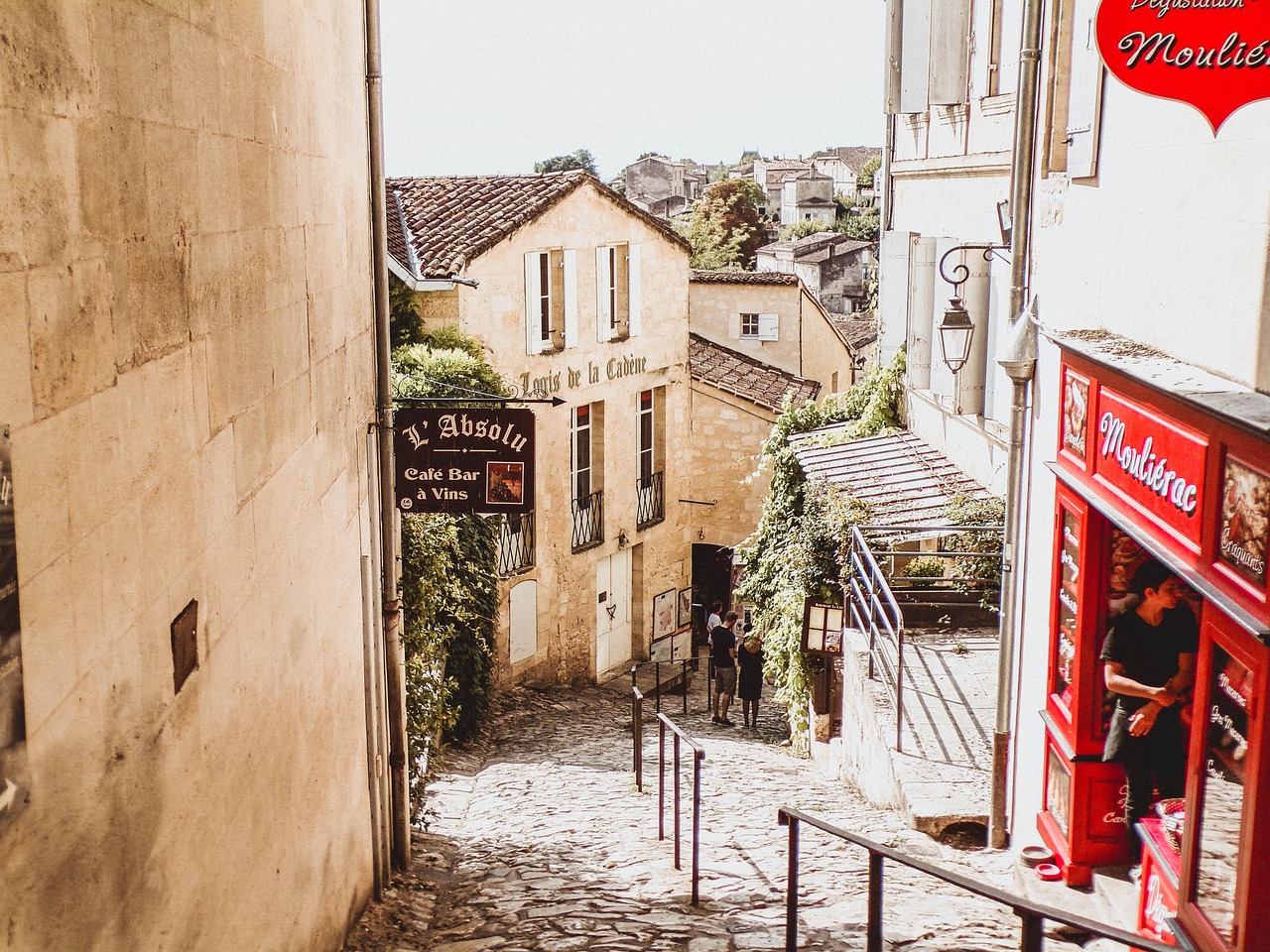 Tourists walking through a charming street in Saint-Emilion France lined with wine shops and historic architecture
