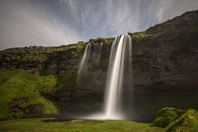 Seljalandsfoss waterfall in Iceland surrounded by green landscape