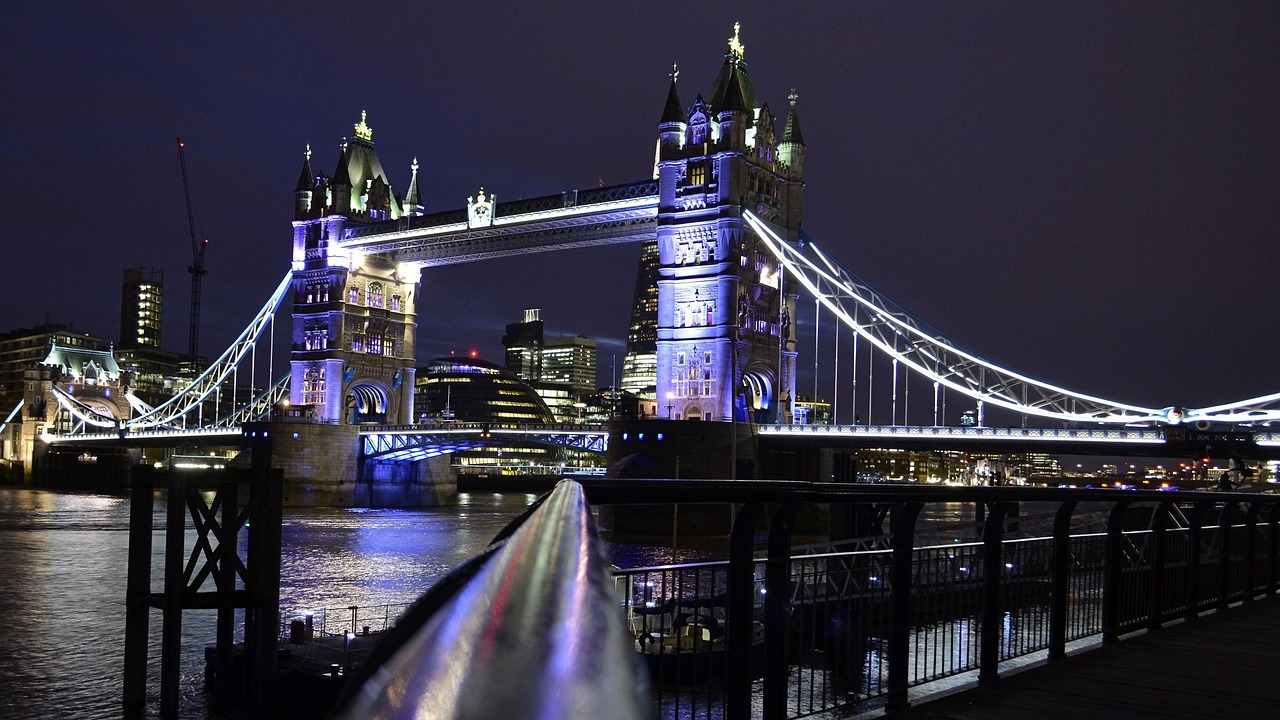 Tower Bridge over the River Thames illuminated at night with reflections in the water