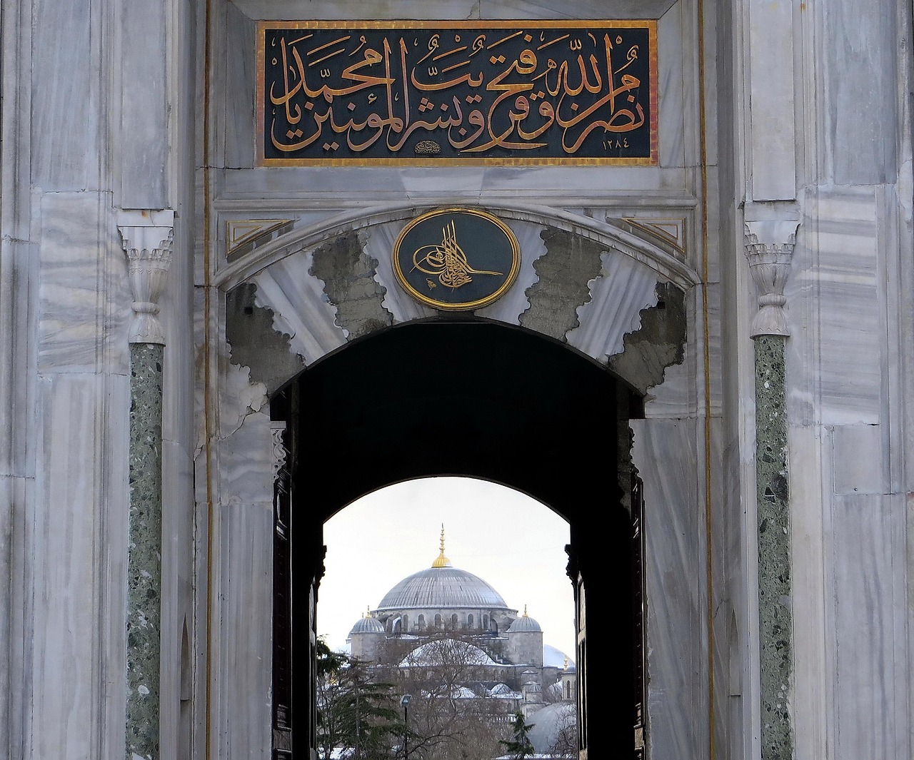 The Imperial Gate entrance to Topkapi Palace with Sultan Ahmed Mosque visible behind