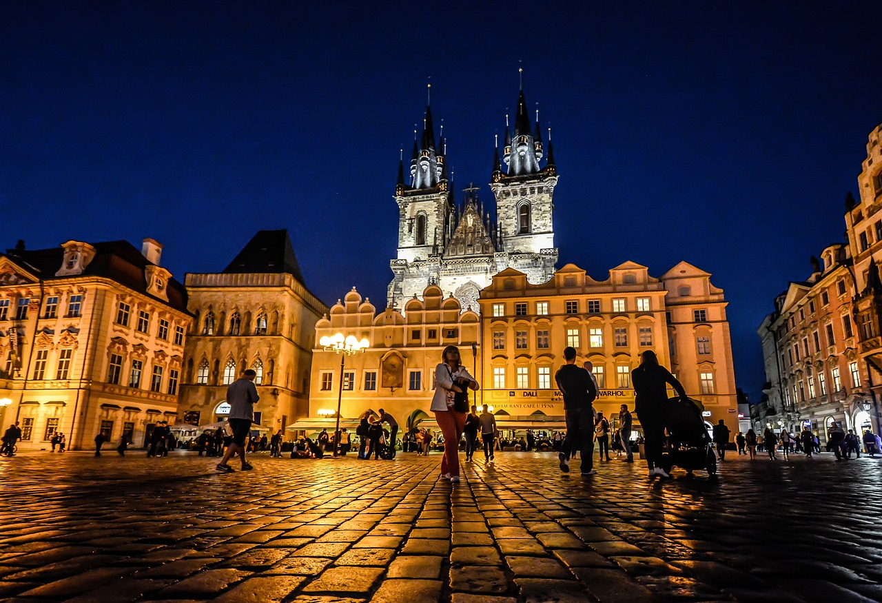 Prague Old Town spires and rooftops illuminated at night under a dark sky