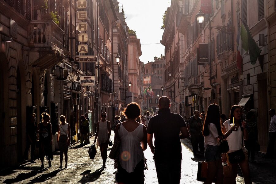 Tourists and locals walking through a narrow alley in Naples Italy