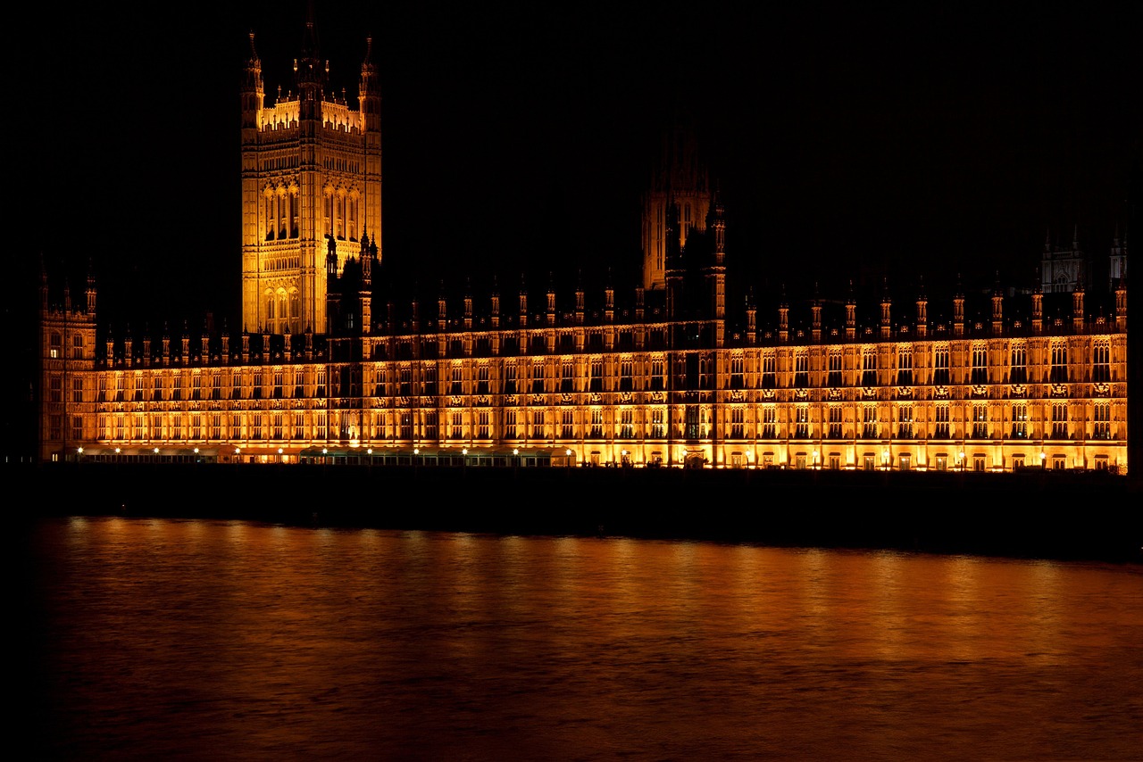 The Palace of Westminster and Elizabeth Tower illuminated at night reflected in the River Thames