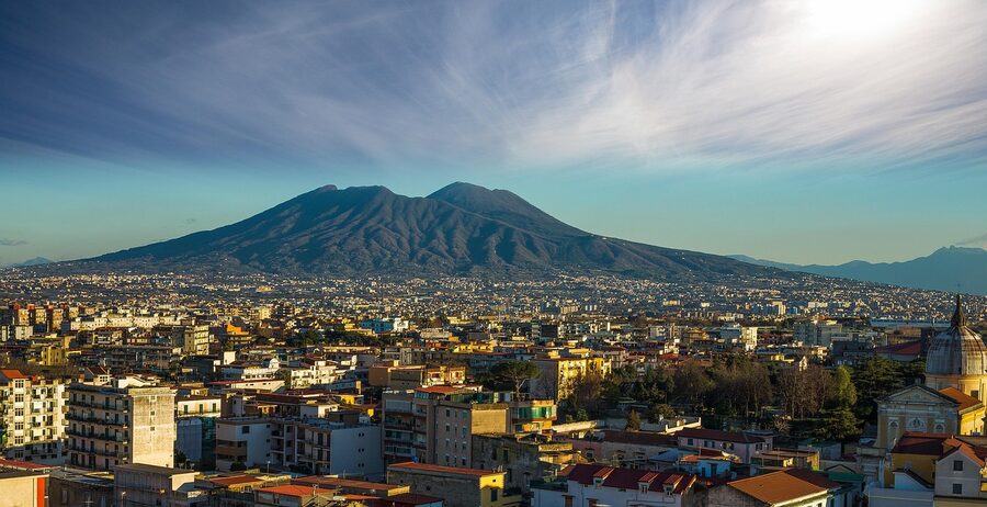 Panoramic aerial view of Naples Italy showing the dense cityscape under blue sky with clouds