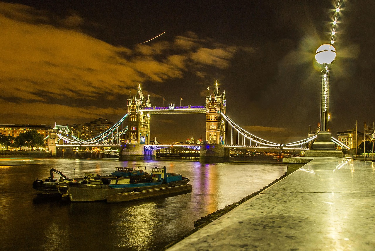 Tower Bridge in London illuminated with blue and white lights at night