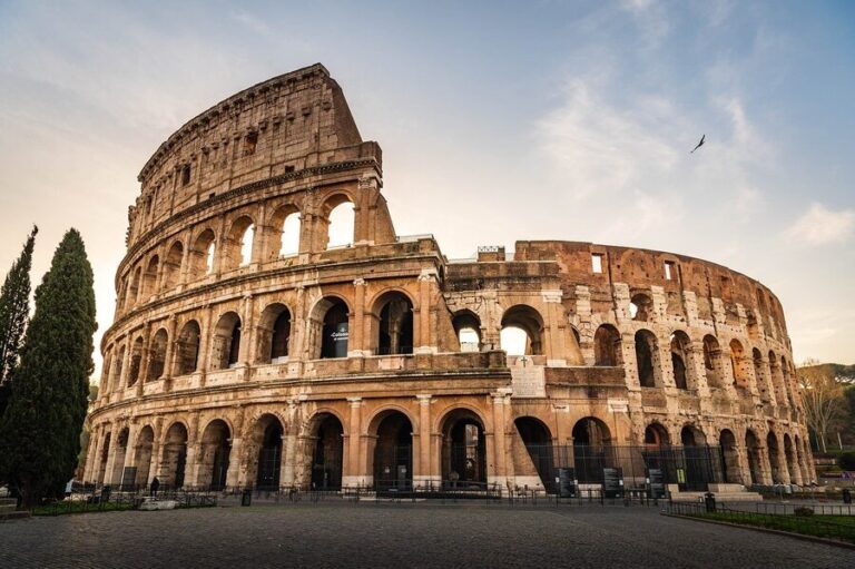 The Colosseum in Rome at sunset with warm golden light on the ancient stone arches