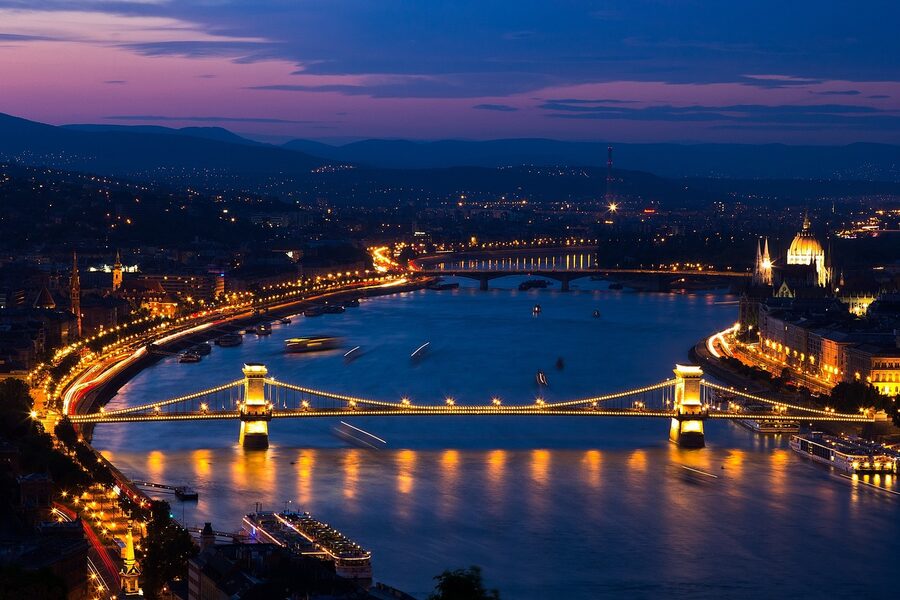Szechenyi Chain Bridge illuminated at night over the Danube River with Budapest city lights