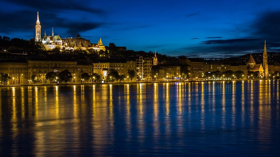 Danube River at night with Buda Castle and bridge reflections in Budapest