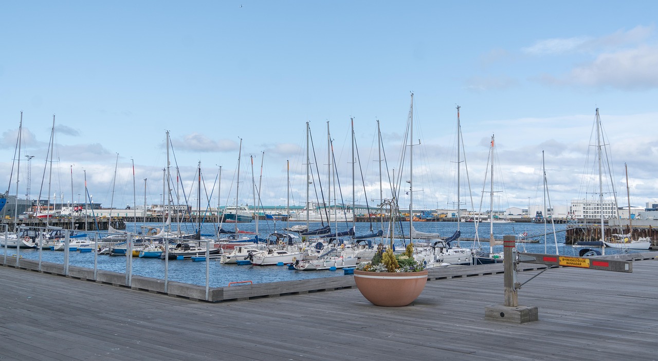 Boats docked at Reykjavik Old Harbour with colorful buildings and mountains