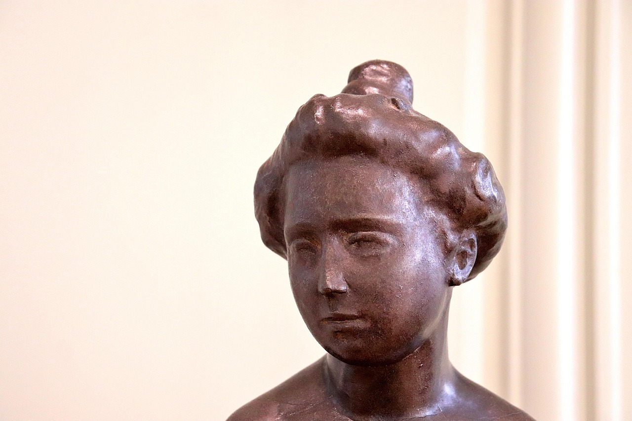 Bronze portrait sculpture by Auguste Rodin showing a young woman with bun hairstyle