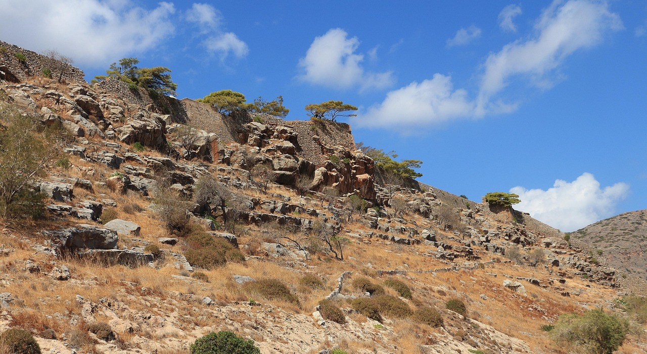 The narrow main street of Spinalonga lined with crumbling walls and doorways