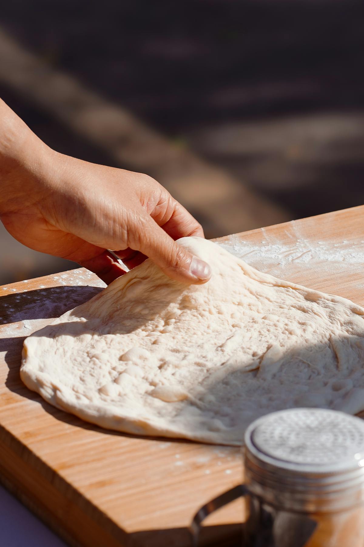 Stretching pizza dough with both hands