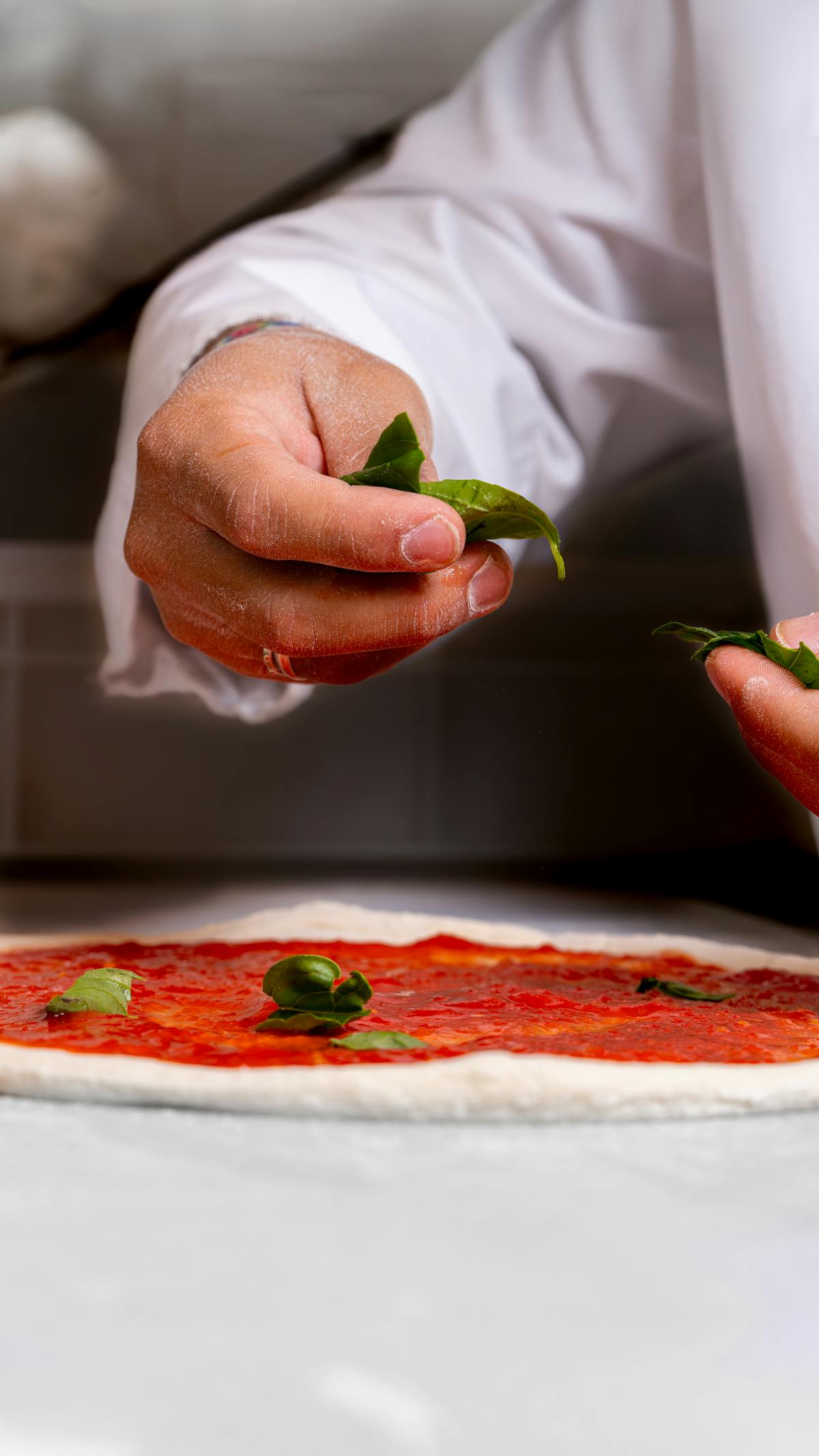 Hands stretching pizza dough during a class in Naples