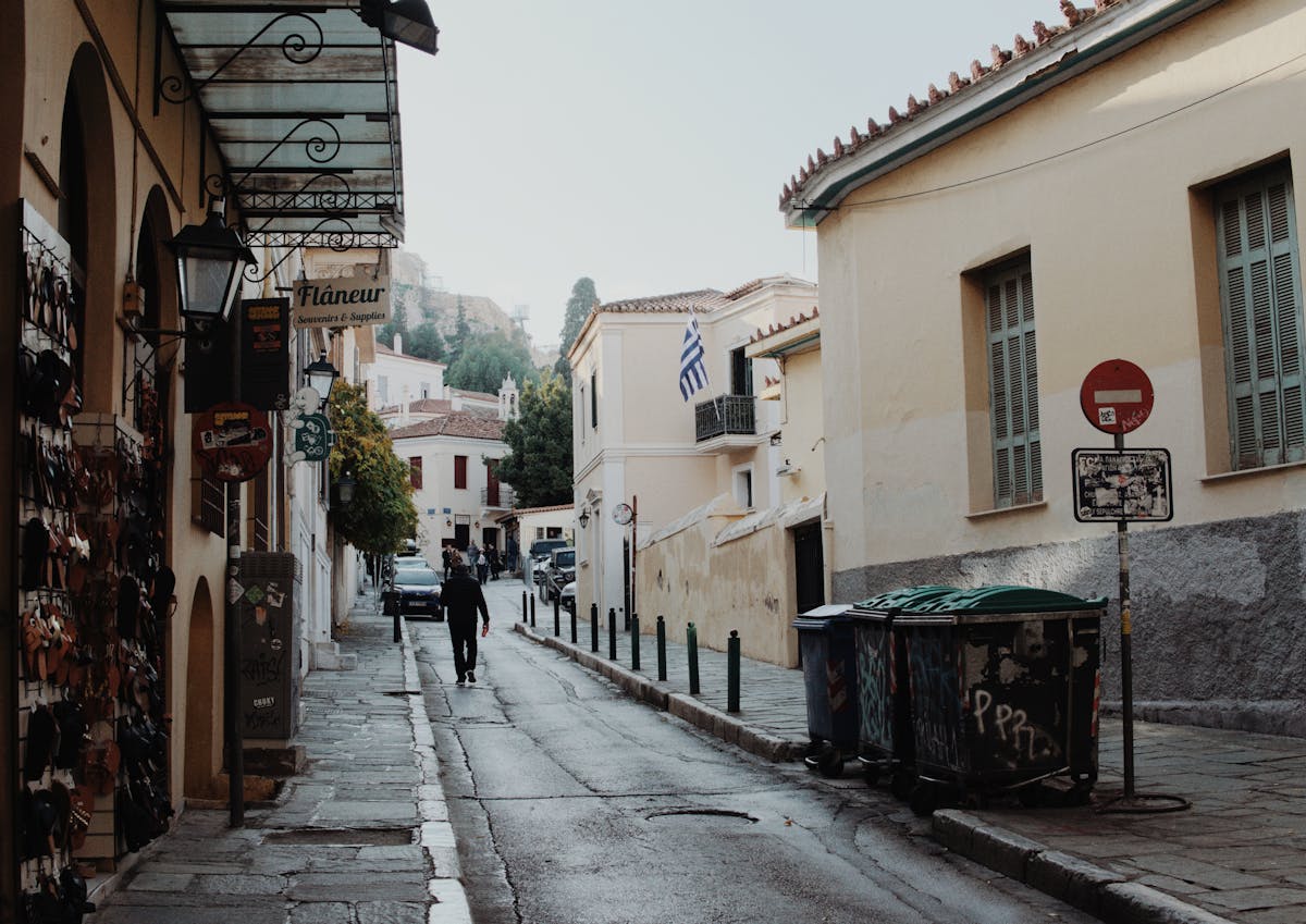 A charming narrow street in the historic Plaka neighbourhood of Athens with a Greek flag