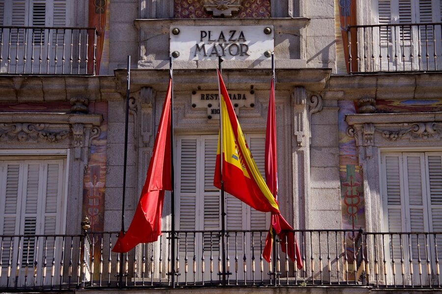 Detailed view of Plaza Mayor facade with flags in Madrid