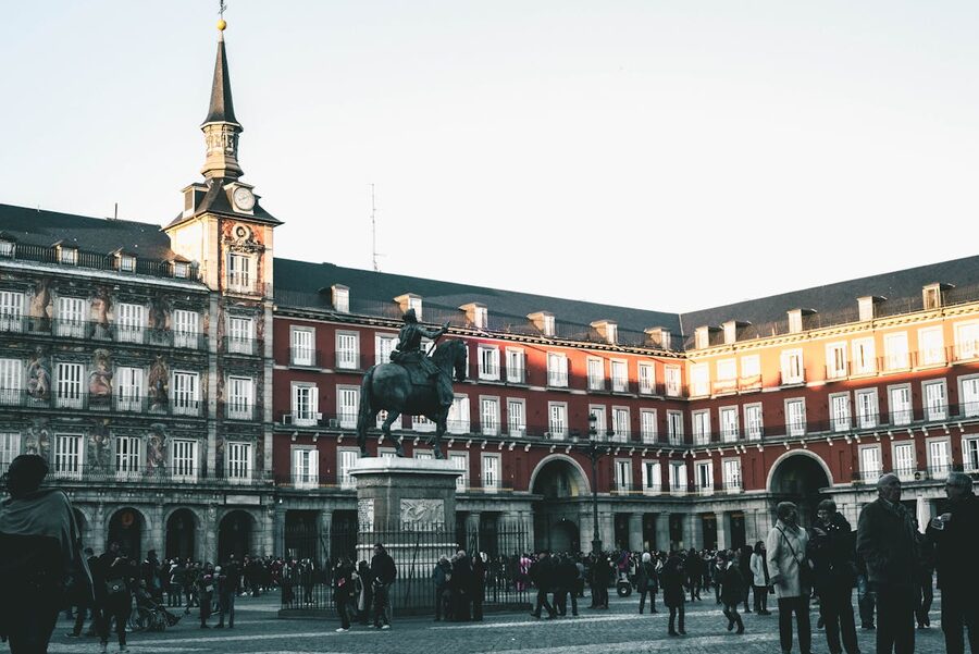 Crowds of people at Plaza Mayor in Madrid with historic buildings