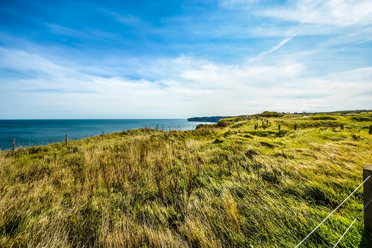 Grassy landscape with bomb craters at Pointe du Hoc overlooking the English Channel