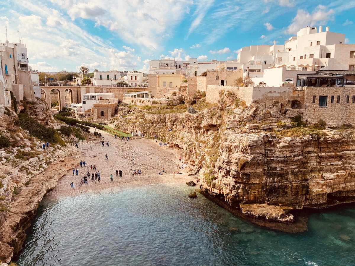 Lama Monachile beach surrounded by tall cliffs and historic buildings in Polignano a Mare