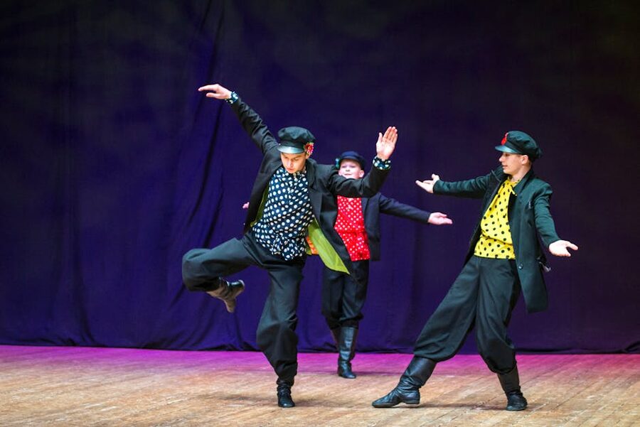 Male folk dancers leaping on stage